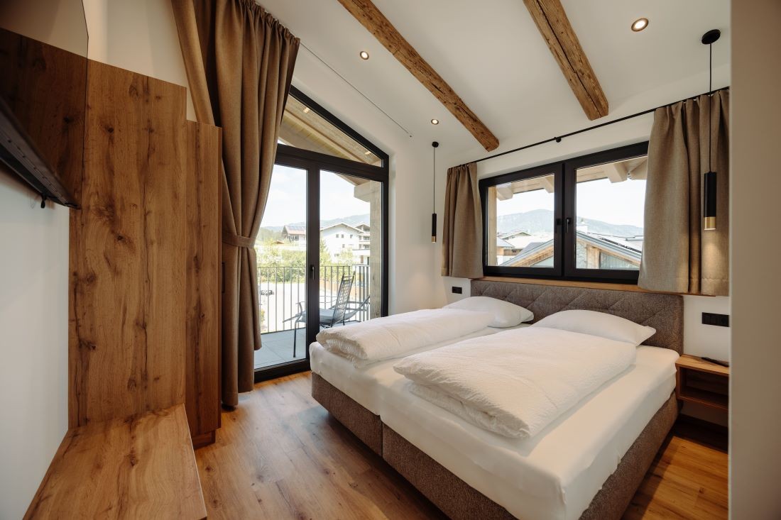Geräumiges Schlafzimmer mit Doppelbett und Balkon